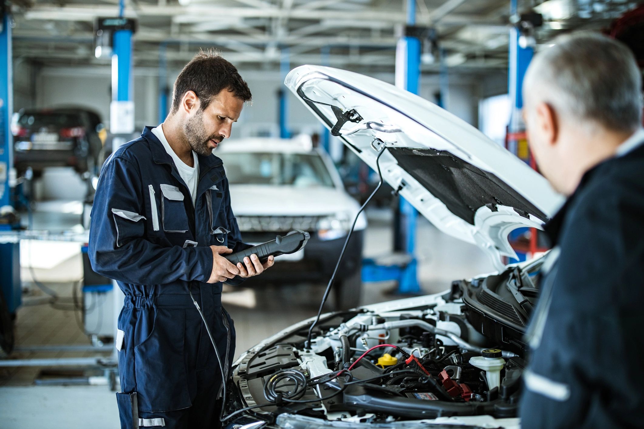Mechanic using a diagnostic tool in an auto repair shop