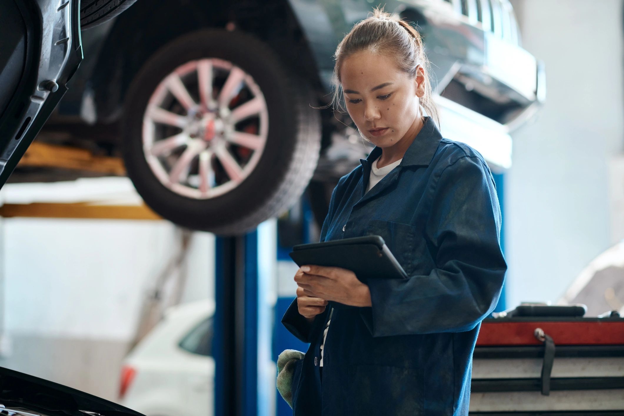 Female mechanic holding a digital tablet in an auto repair shop