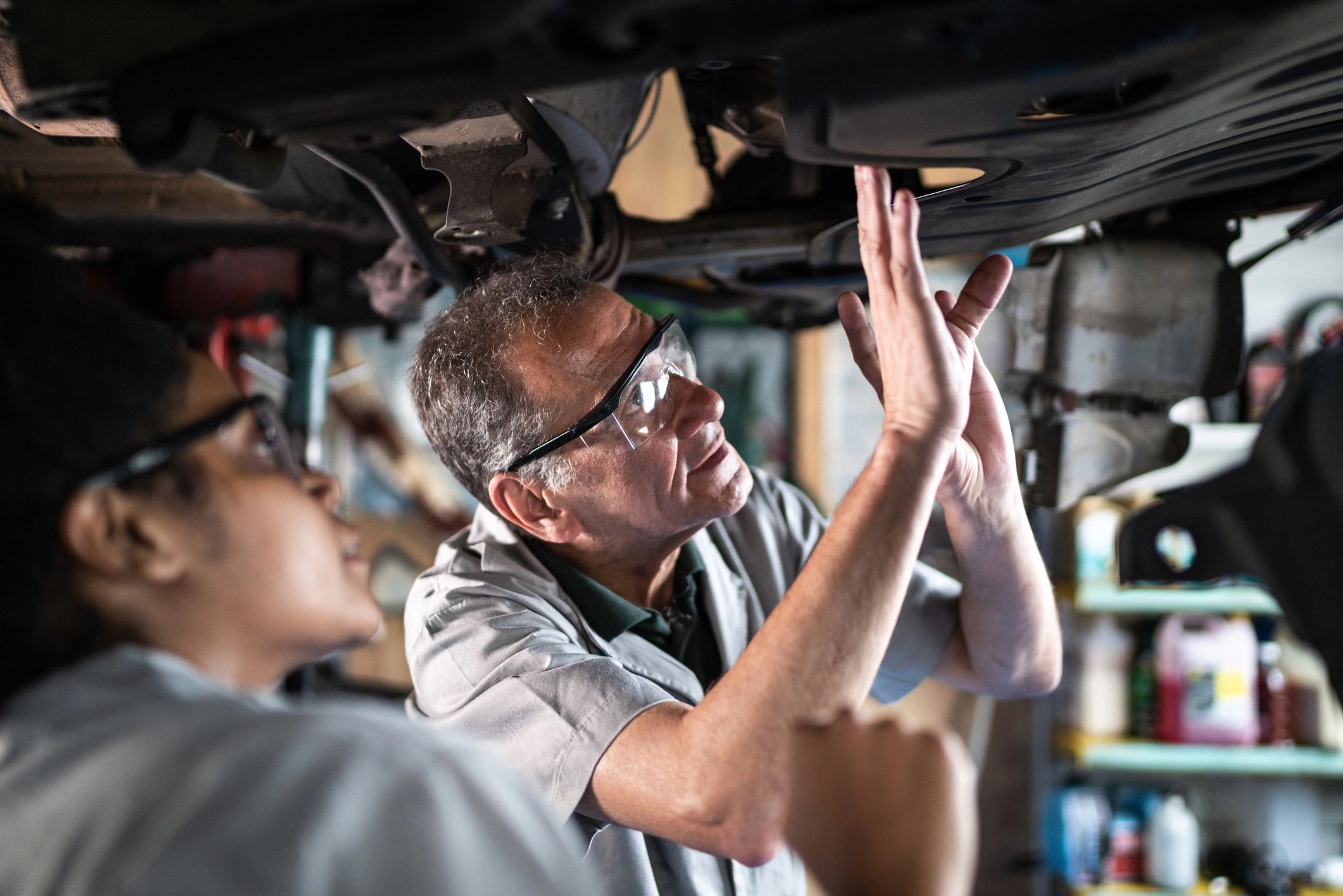 Senior mechanic teaching an assistant in a repair shop