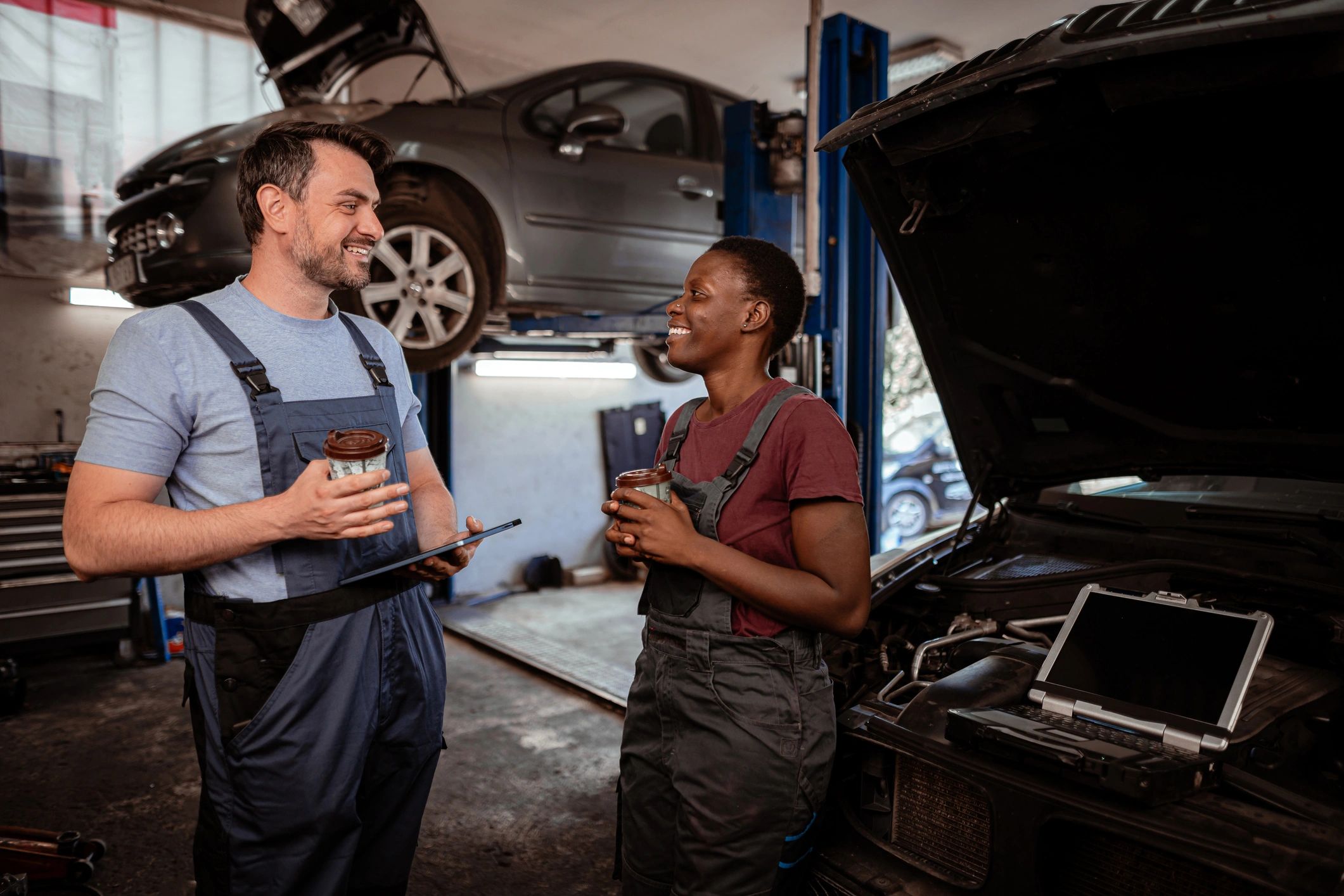 Two mechanics talking in an auto repair shop