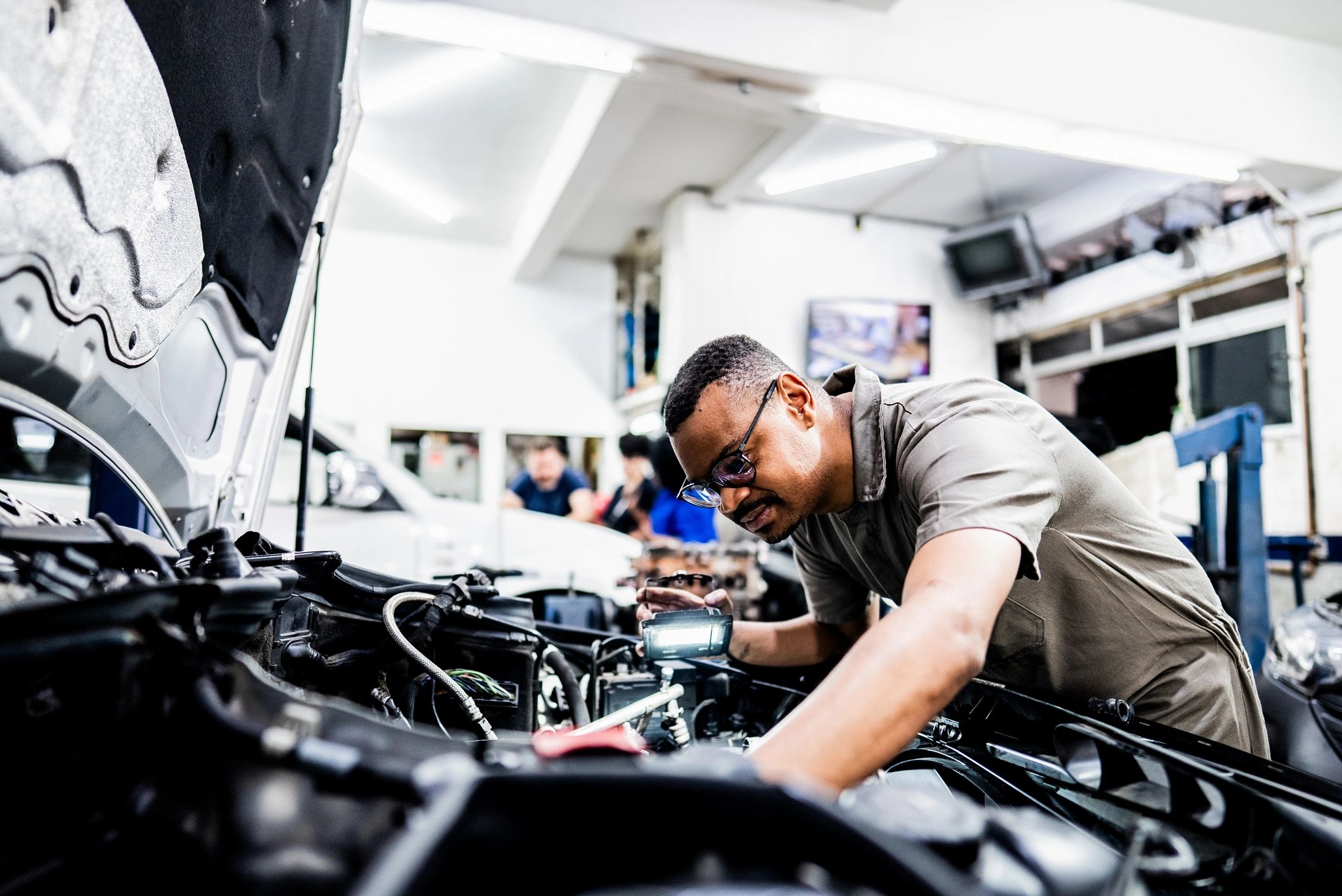 Technician working under the hood performing engine service