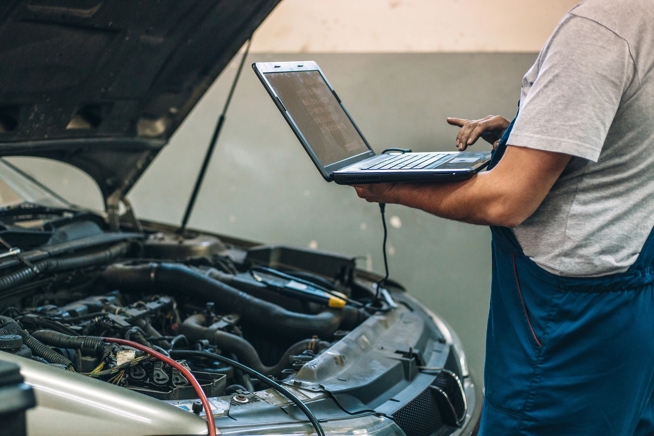 Technician using a diagnostic scanner inside a vehicle